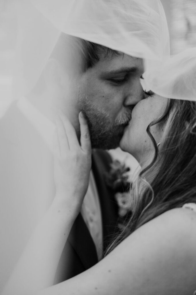 zwart-wit kus onder de sluier bruiloft